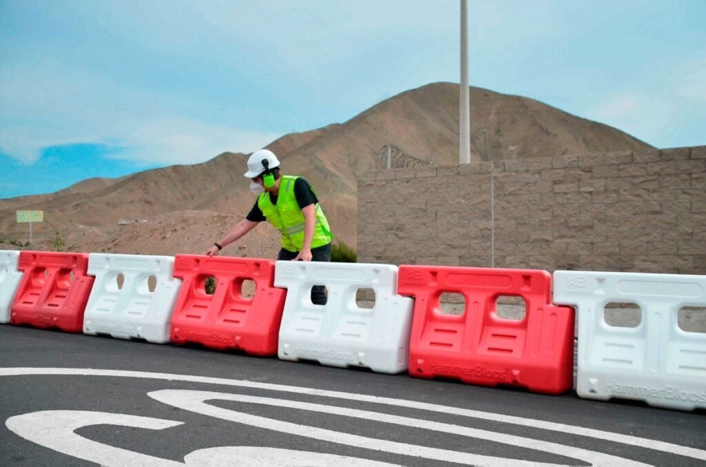Línea de barreras viales New Jersey rojas y blancas en una obra vial